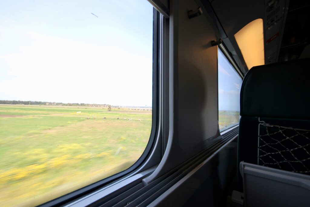 Watching the scenery roll by outside a window in a second-class carriage while travelling from Marrakech to Casablanca