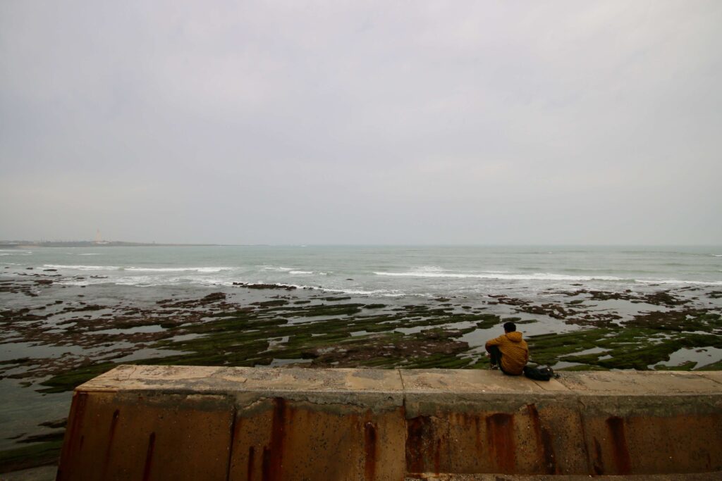 A young Moroccan looks out across the Atlantic Ocean from the Corniche in Casablanca