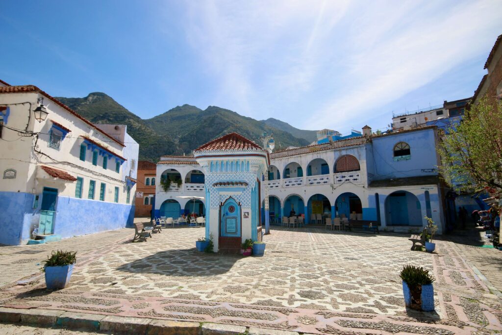 Blue and white buildings frame a sunny square in Chefchaouen