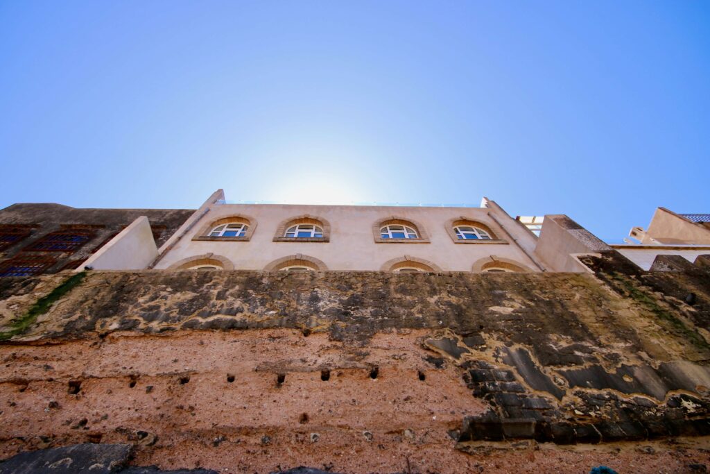 Is August a good time to visit Essaouira? A building rises above the Essaouira ramparts in Morocco