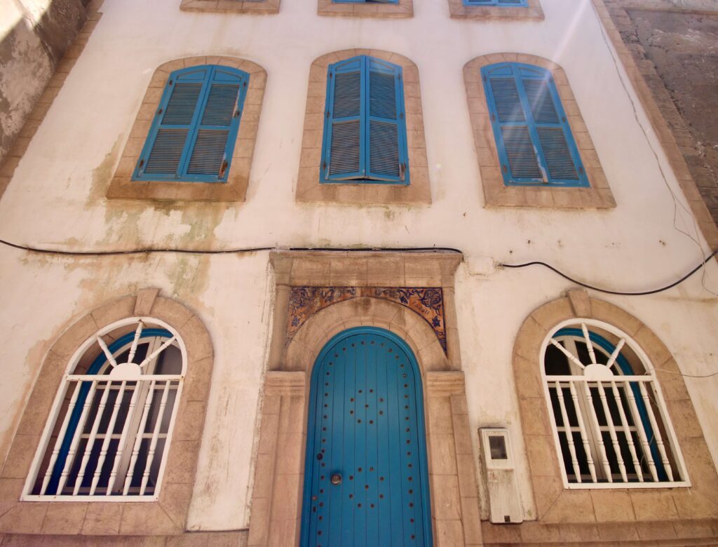 Best art galleries in Essaouira - A blue door and shuttered windows on a whitewashed building in Essaouira