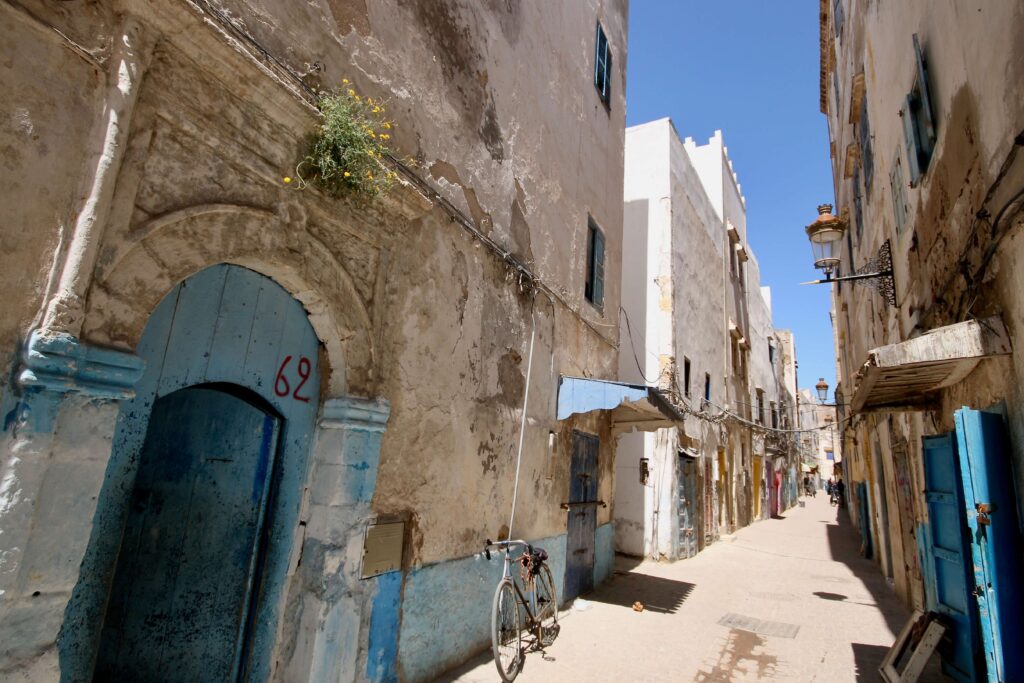 Blue and white buildings line a narrow street in the Essaouira medina
