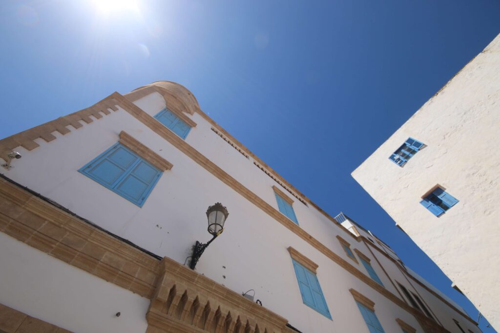 Visiting Essaouira in March - A whitewashed building with blue shuttered windows in the Essaouira medina