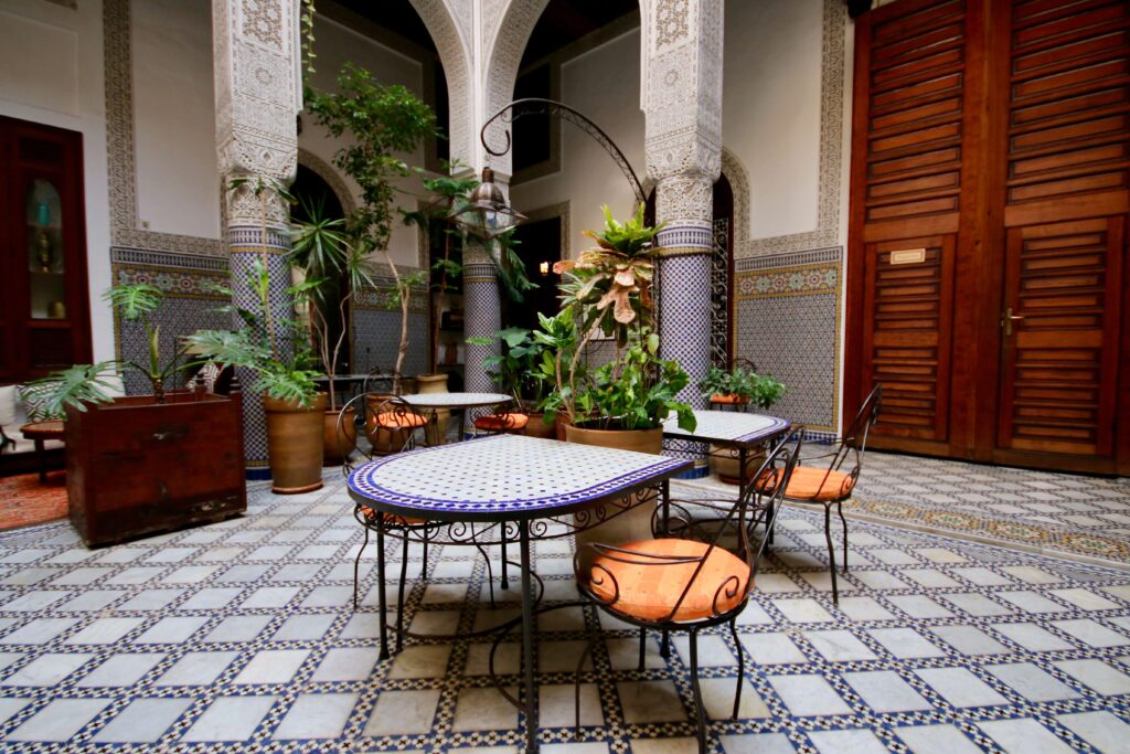 Plants and antiques decorate the interior courtyard of Riad Al Bartal in Fes