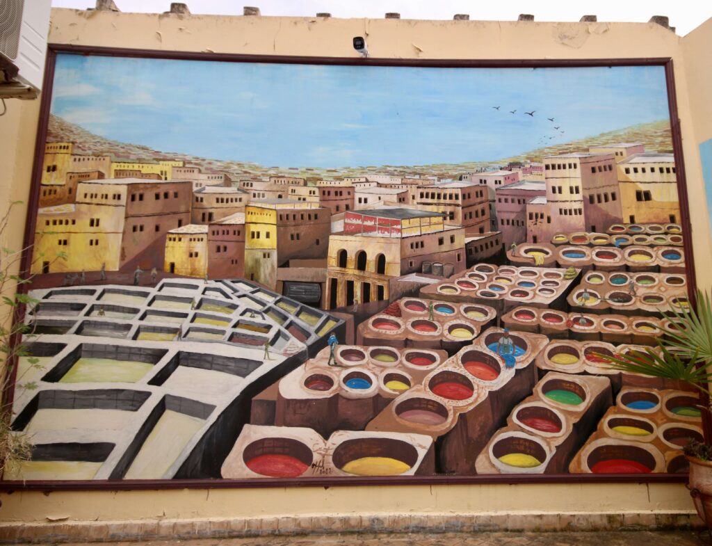 A painting depicts the tanneries of Fes - visiting is one of the best things to do in Fes in September