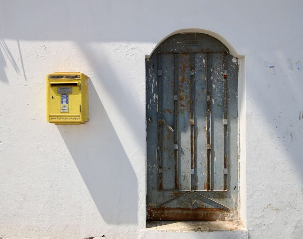 A bright yellow postal box on a whitewashed building in Rabat