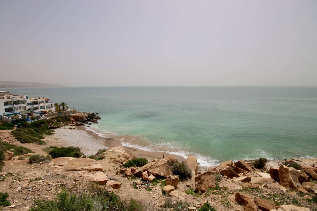 Looking across a pebbly cove on the edge of Taghazout