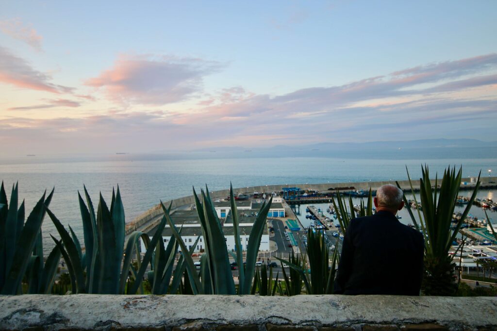 Reasons to visit Tangier - A Moroccan man watches the sunset over the Tangier port from Bab Al Bahr.