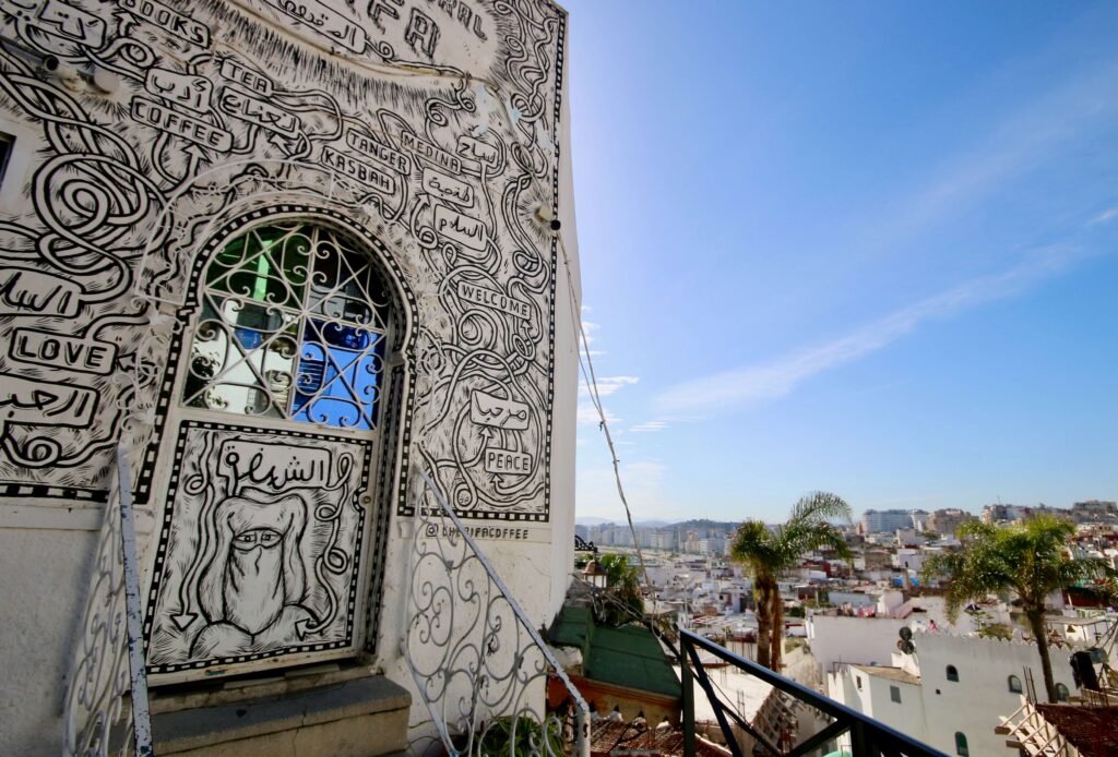 Art adorns a cafe overlooking the whitewashed buildings of Tangier
