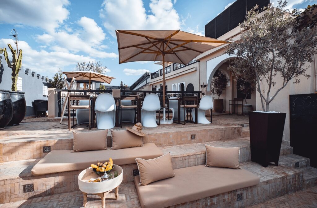 A multi-tiered rooftop terrace at Ambre Epices Medina Riad, a highly-rated Marrakech riad with a fireplace