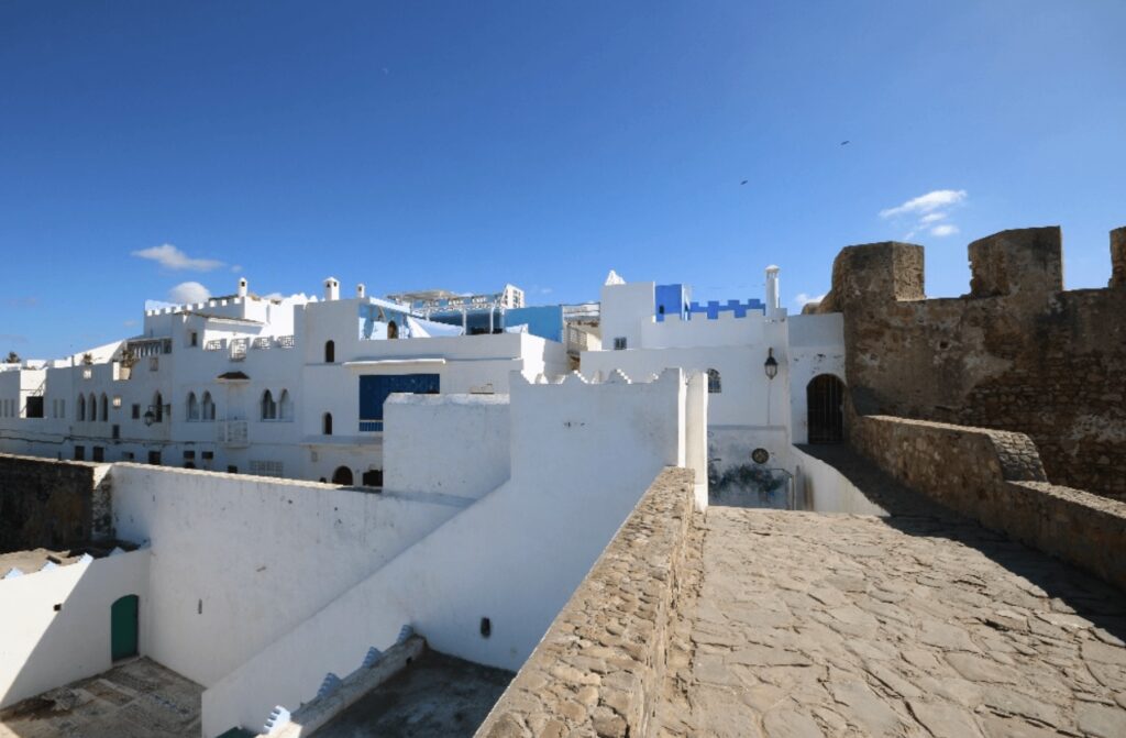 Stone ramparts lead to the whitewashed buildings of the Asilah medina