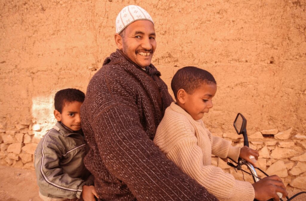A father and his two children on a motorbike in Morocco