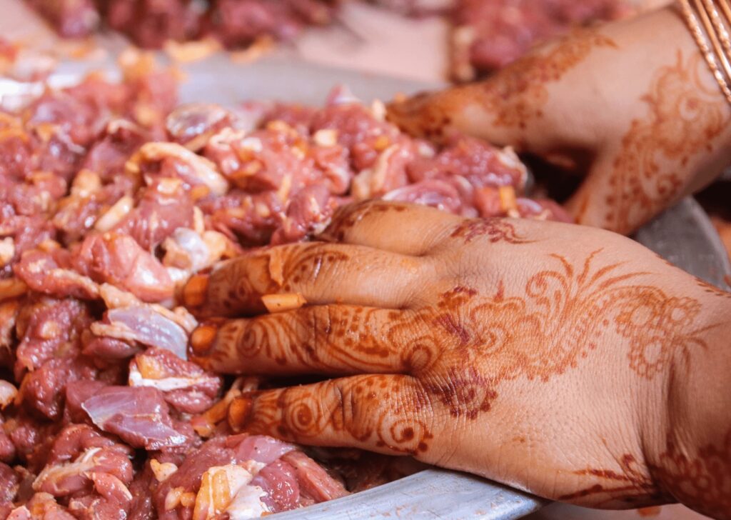 A woman's hennaed hands prepare meat for Eid al-Adha in Morocco