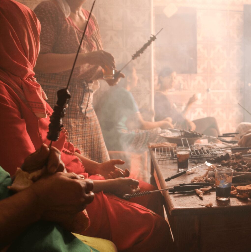 Moroccan women prepare skewered kebabs during Eid al-Adha
