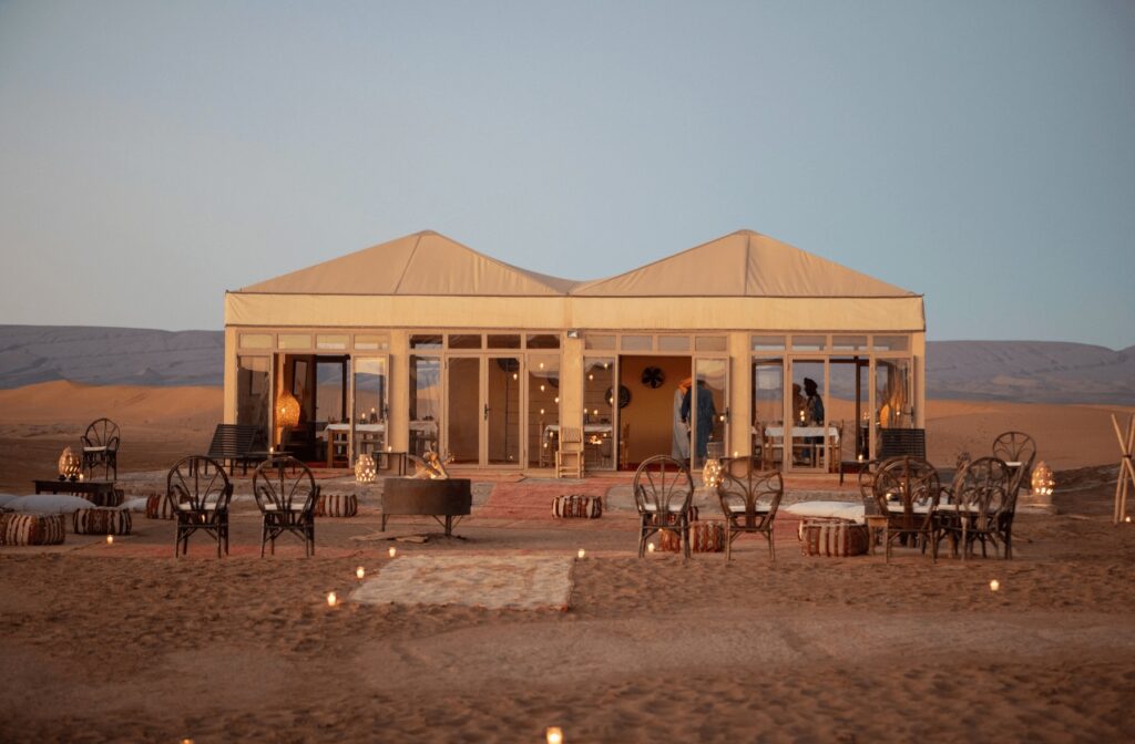 Tables set around open fires at Erg Chigaga Luxury Desert Camp near M'Hamid El Ghizlane 