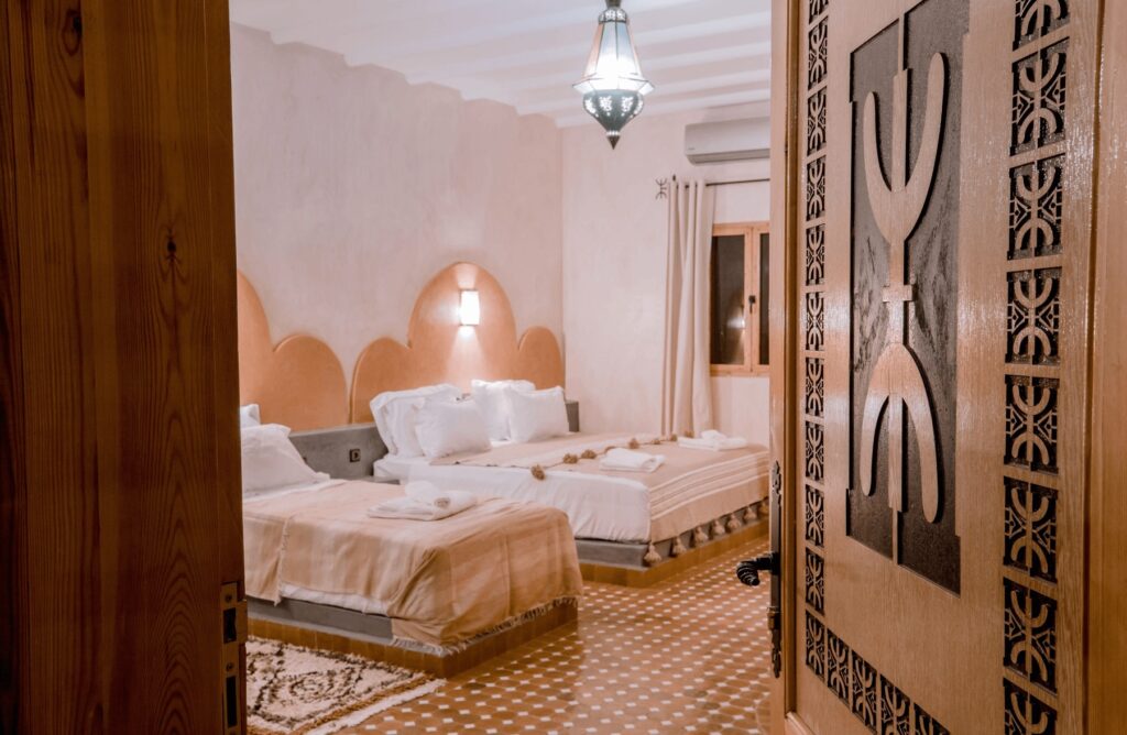 An ornately carved door leads to a spacious room at one of the best kasbah hotels in Merzouga