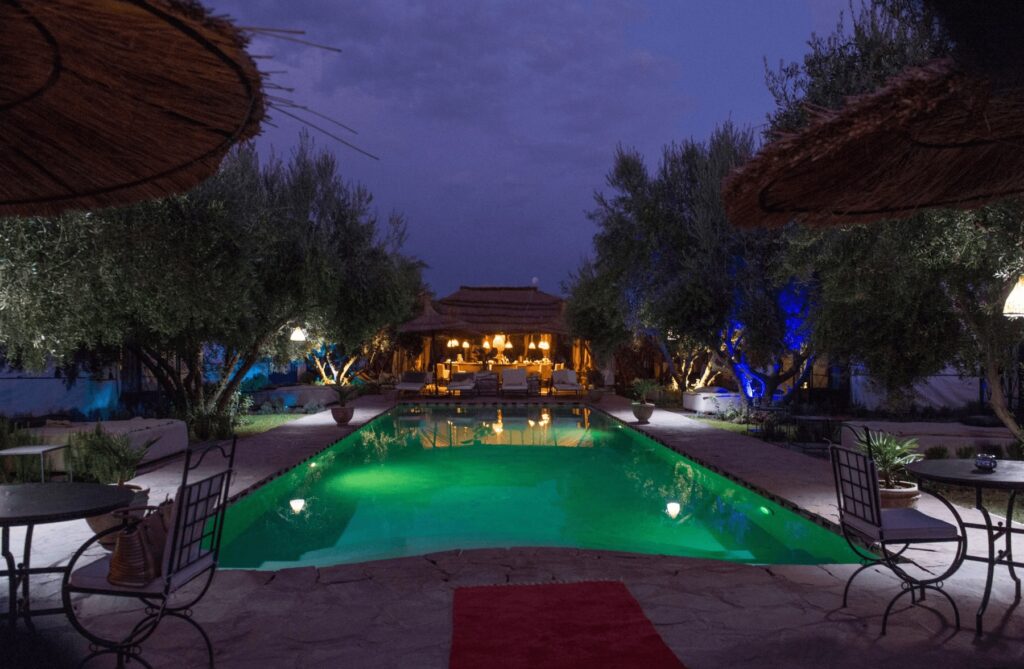 A nighttime scene poolside at Hotel & Spa La Ferme El Dar, one of the best budget hotels near Marrakech
