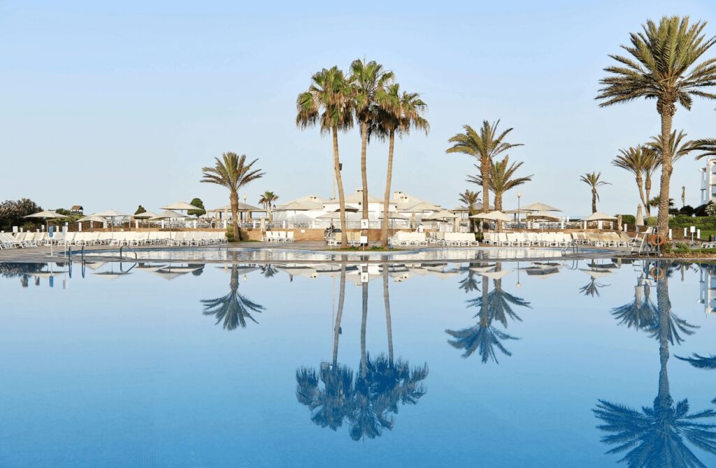 Palm trees reflected in the swimming pool at Iberostar Waves Founty Beach