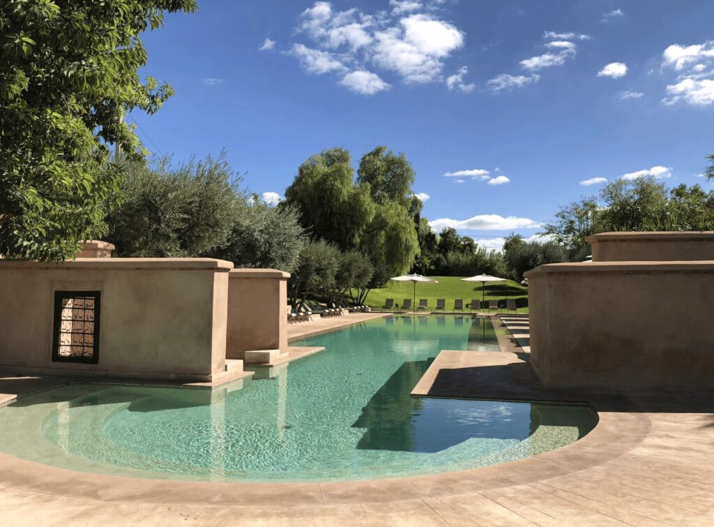 Grottos frame the gorgeous swimming pool at Les Deux Tours, one of the best hotels in Marrakech with a pool