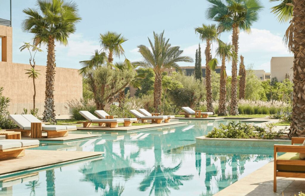 Palm trees frame a swimming pool at a luxury golf hotel in Marrakech