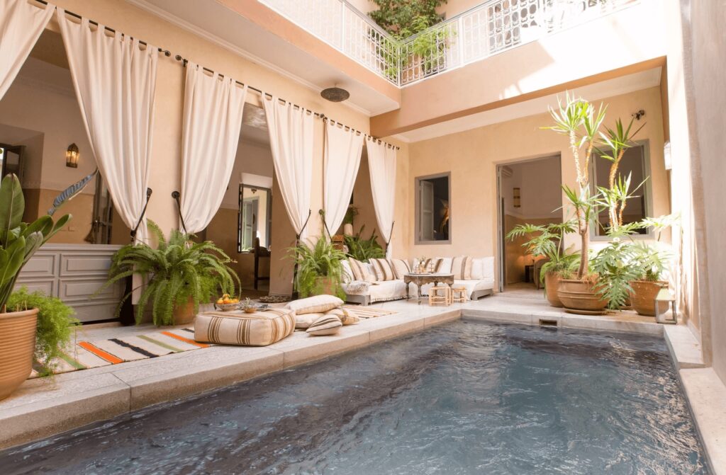 Cushioned loungers frame the courtyard pool at Riad Olema & Spa in Marrakech