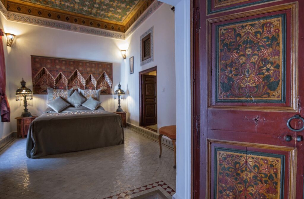 A painted door leads to a beautifully decorated room at Riad Palais Sebban