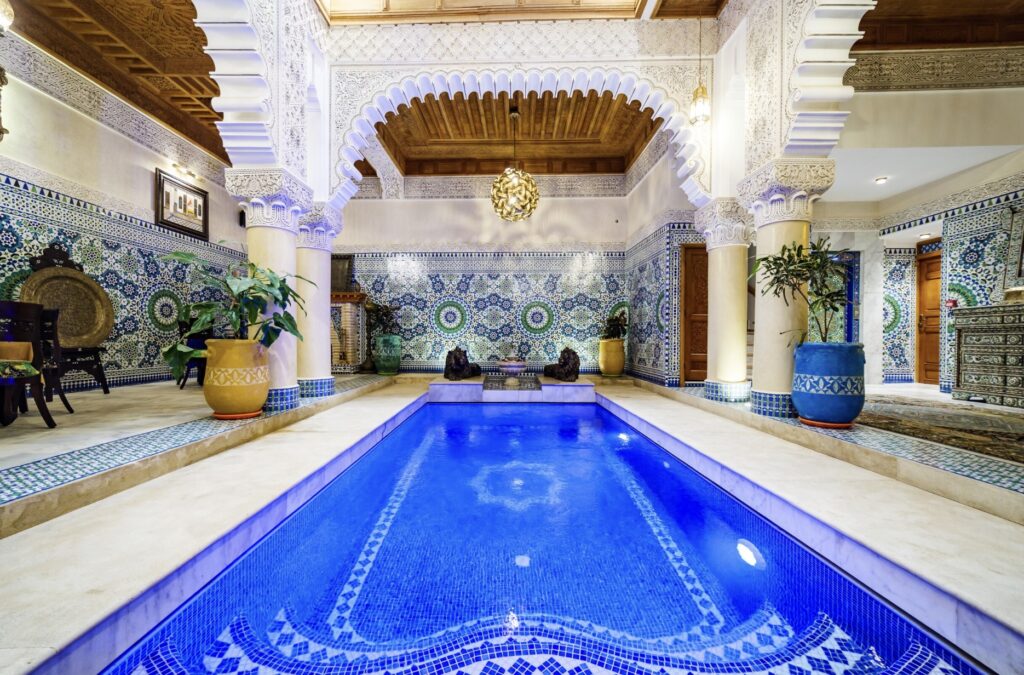 Colourful zellige tiles surround a swimming pool at Riad Rcif Alif Suite & Spa in Fes 