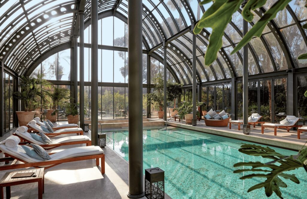 A glass atrium surrounds an indoor pool at the Royal Mansour Marrakech, one of the best luxury hotels in Marrakech with a pool