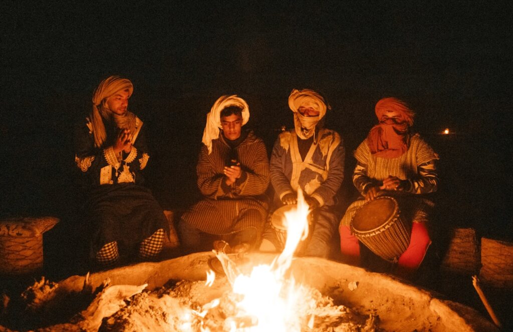 Amazigh musicians around a campfire at a desert camp in the Moroccan Sahara