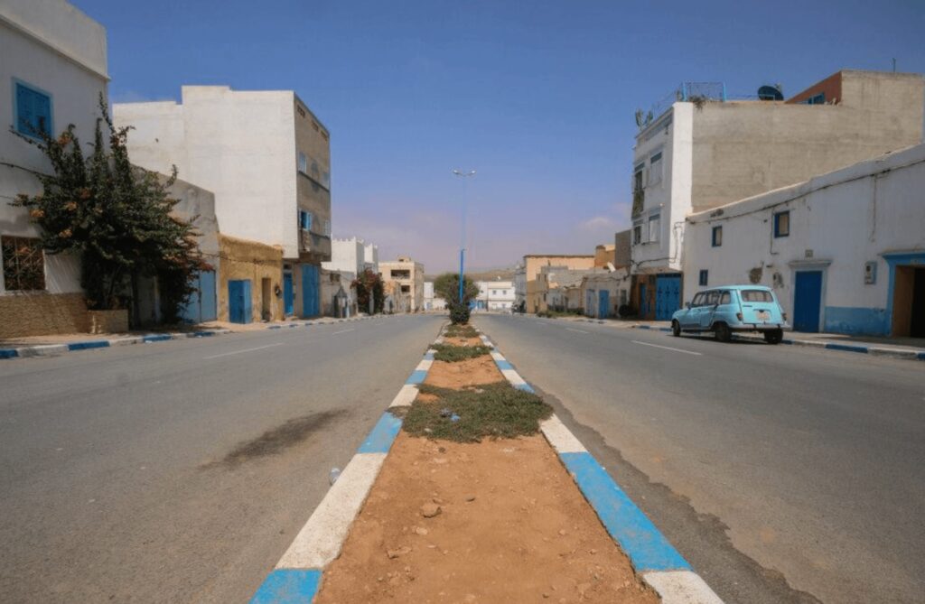 Is Sidi Ifni worth visiting? Blue and white buildings line a street in Sidi Ifni, Morocco