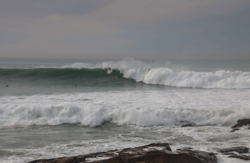 A surfer rides a wave at Anchor Point, the most famous wave in Taghazout