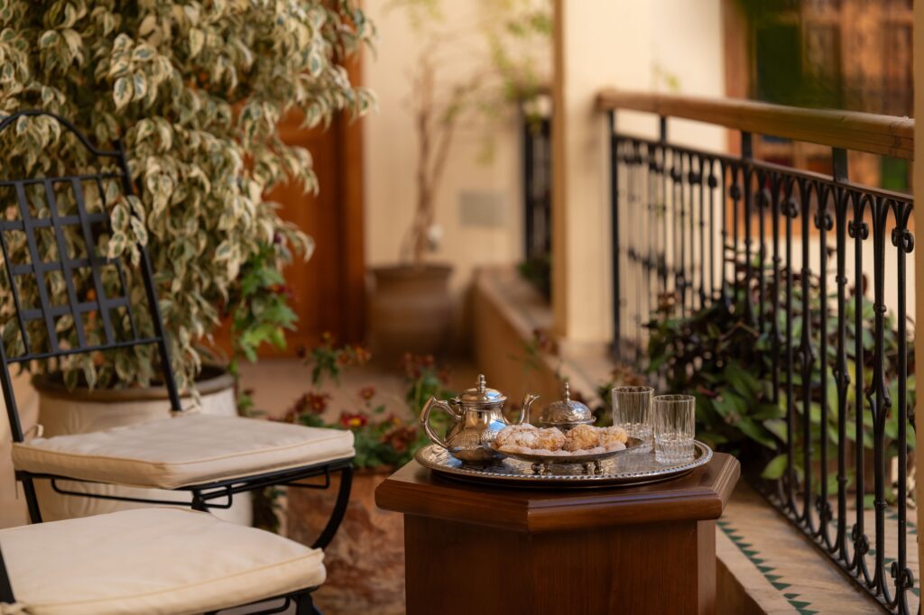 Enjoying Moroccan tea on a balcony at Riad Al Ansari, one of the best family riads in Fes